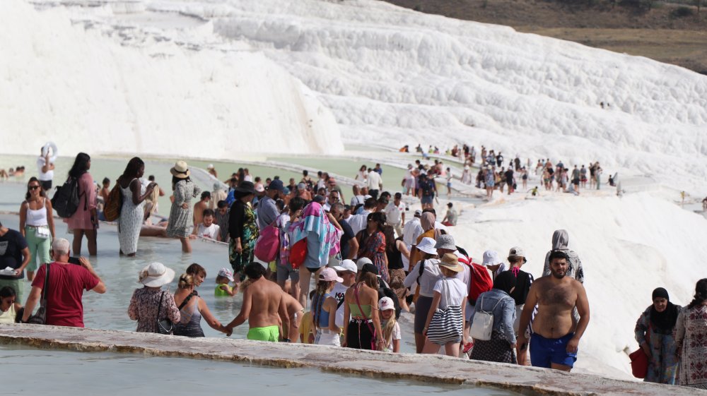 Denizli'de 40 dereceyi bulan kavurucu sıcaklardan kaçan yerli ve yabancı turistler, UNESCO Dünya Miras Listesi’nde yer alan beyaz cennet Pamukkale’ye akın etti.