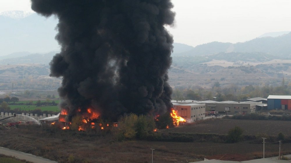 Denizli'nin Pamukkale ilçesinde, araç kimyasalları üretilen fabrikada 2 saattir devam eden yangından yükselen dumanlar gökyüzünü kapladı.